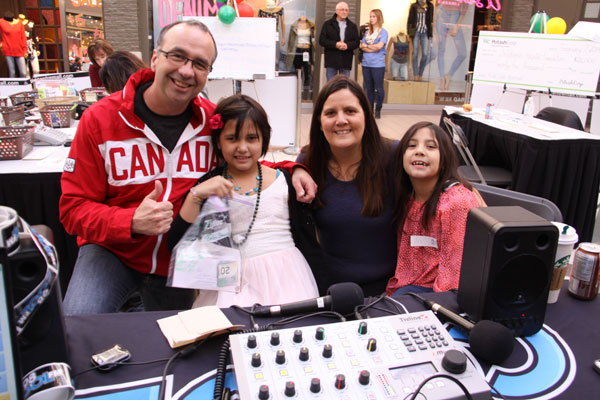 Radio host Steve Chisholm accepts a $1,400 donation from Bella, her mom, Bev Lafond, and sister Ava.